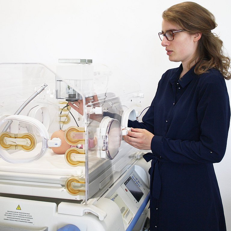 Doktorandin Johanna Gleichauf hängt die Sensorbox mit unterschiedlichen Kameras zur kontaktlosen Überwachung in den Inkubator. Bild: Karin Gleichauf 