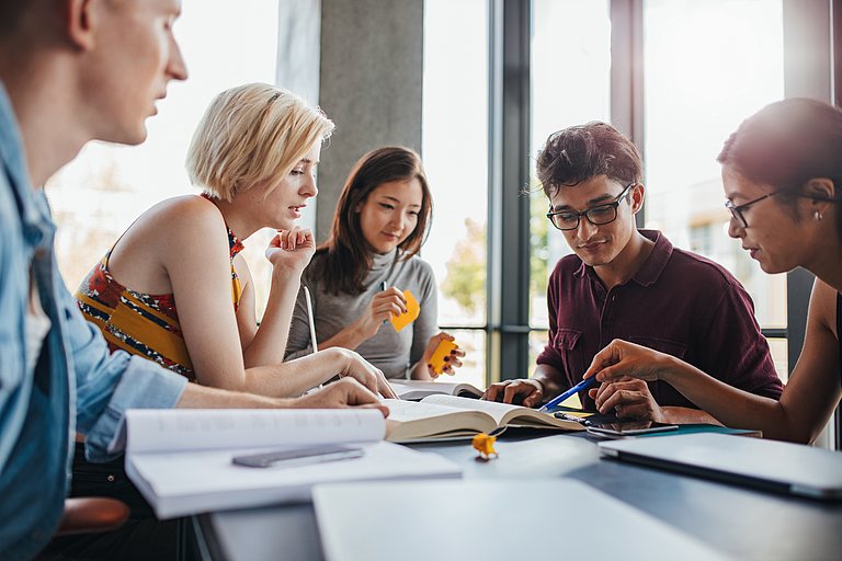 Gruppe bei der Arbeit mit Büchern