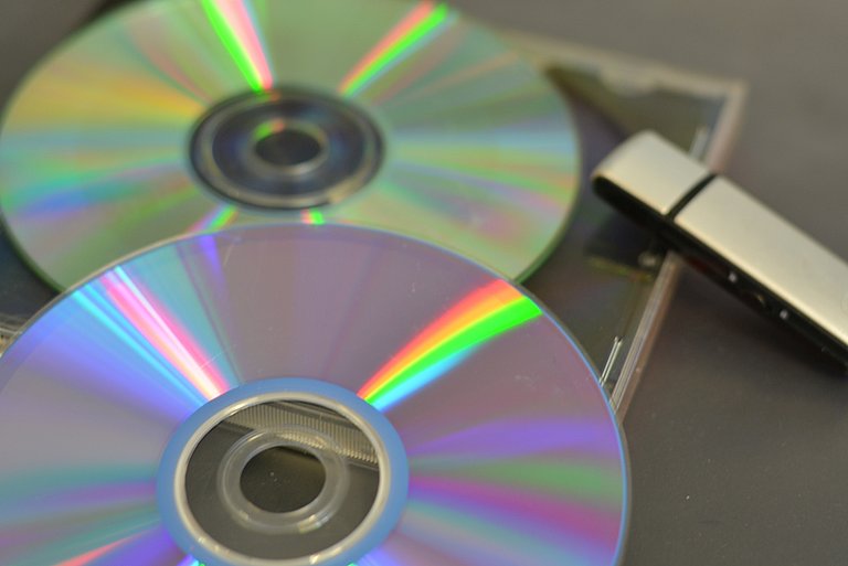 Ein Stapel mit Datenträgern CD/DVD und USB Stick repräsentiert den Bereich Software