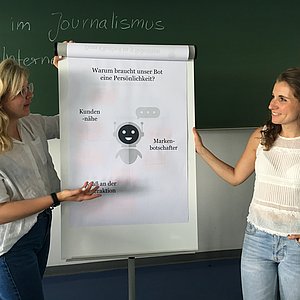 Das Bild zeigt zwei Studierende bei der Präsentation ihrer Ergebnisse.