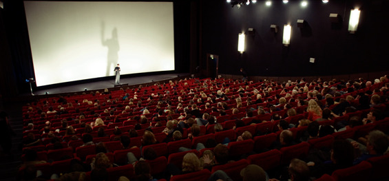 Kino 1 des Cinecittá Nürnberg, eine Person auf der Bühne vor der noch leeren Leinwand
